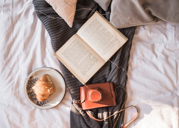 Buch und Fotokamera auf Decke gelegt