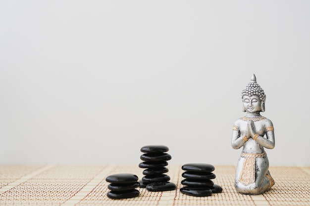 Buddha-Figur mit schwarzen Steinen