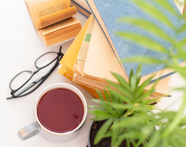 Bücherarrangement mit Tasse und Gläsern