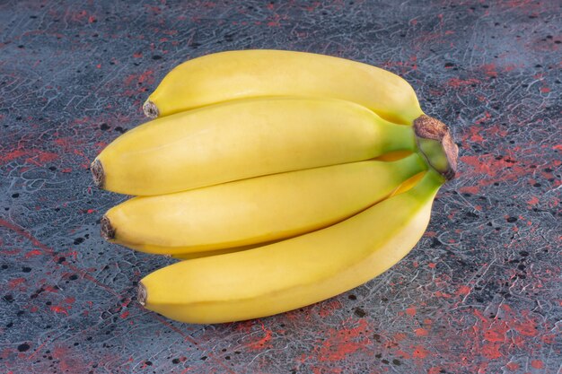 Bündel Bananen isoliert auf bunter Oberfläche