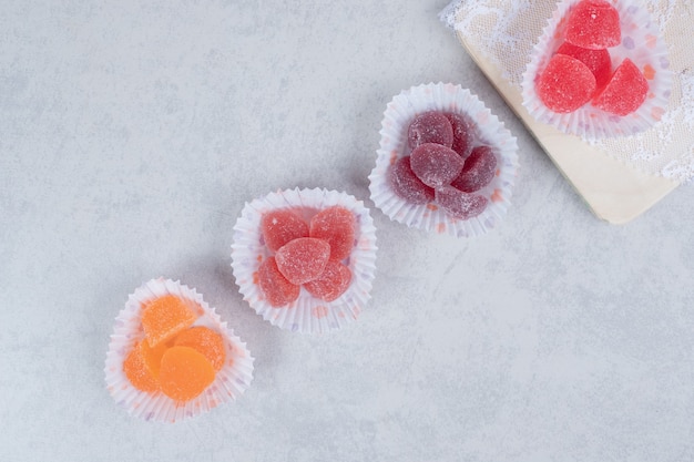 Bündel bunte Marmeladen auf grauem Hintergrund.