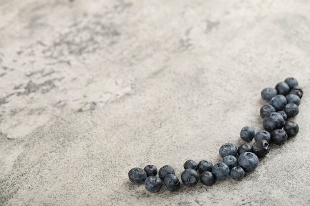 Bündel der frischen köstlichen Blaubeeren, die auf Steinhintergrund gelegt werden.