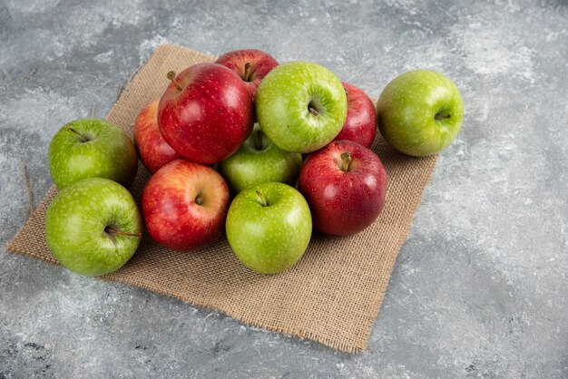 Bündel frische grüne und rote Äpfel auf Leinwand gelegt.