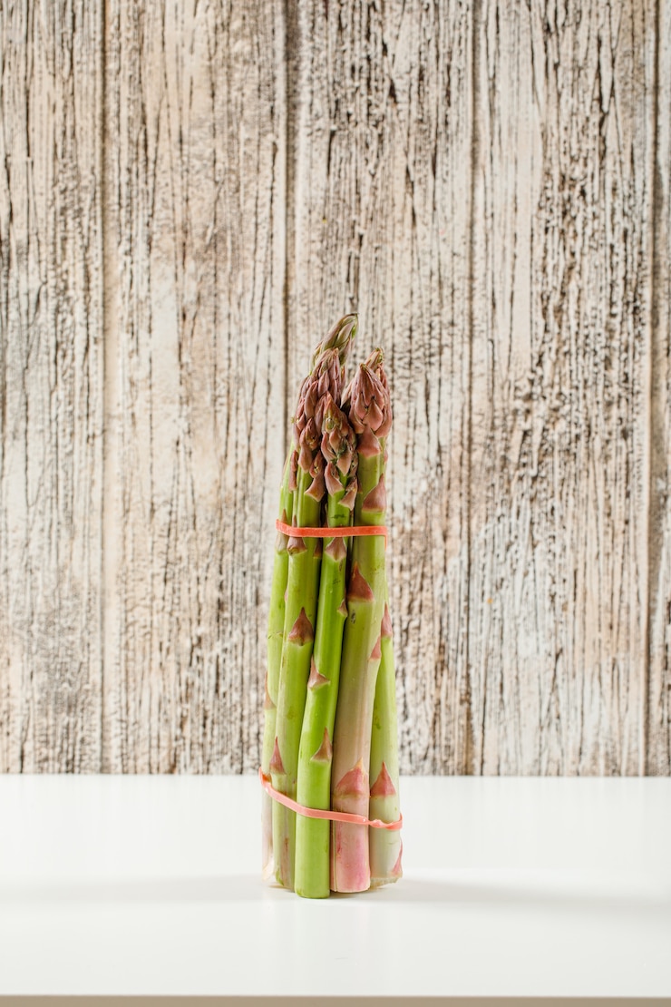 Kostenlose Foto bündel frischer grüner spargel auf grunge-holz und weißer oberfläche