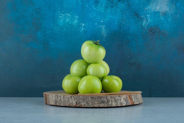 Bündel grüne Tomaten auf Holzstück.