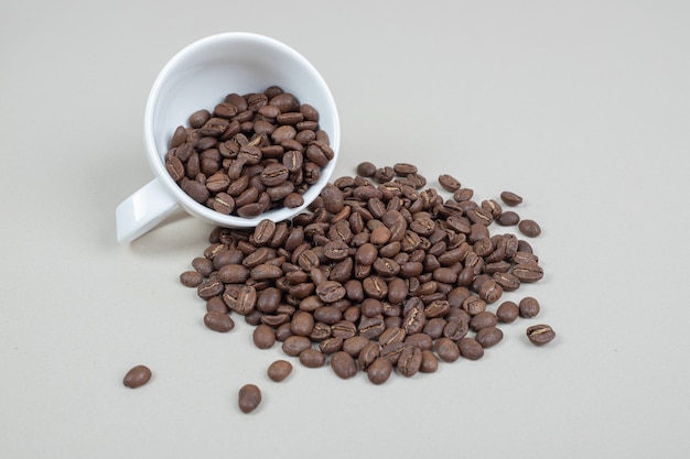 Bündel Kaffeebohnen aus weißem Becher