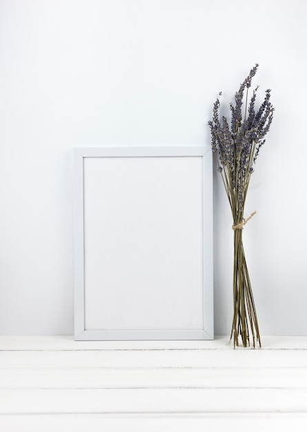 Bündel Lavendel blüht mit leerem Rahmen auf hölzernem Schreibtisch