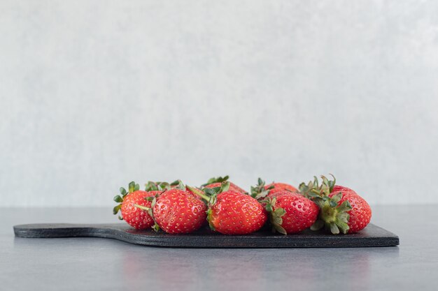 Bündel reife Erdbeeren auf Holzbrett. Foto in hoher Qualität