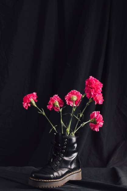 Bündel rosafarbene Blüte im dunklen Stiefel