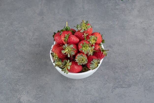 Bündel rote Erdbeeren in weißer Schüssel. Foto in hoher Qualität