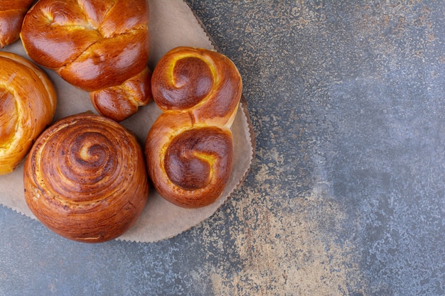 Bündel süßer Brötchen auf einem Holzbrett auf Marmoroberfläche