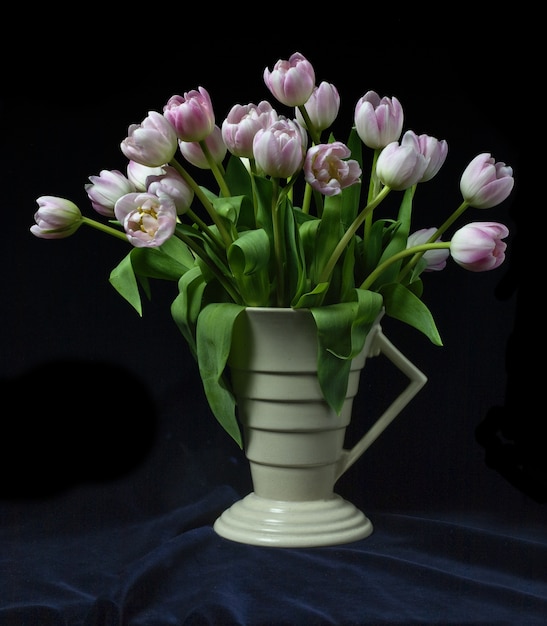 Bündel Tulpen in einer Art-Deco-Vase mit schwarzem Hintergrund