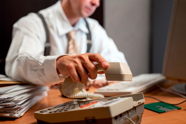 Büro im Vintage-Stil der 90er Jahre mit einer Person, die an einem Schreibtisch arbeitet