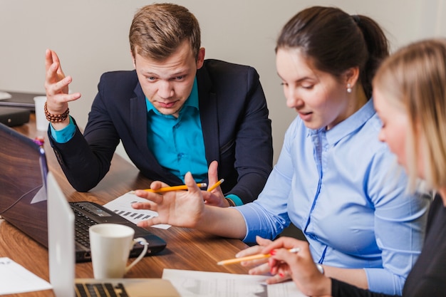 Kostenloses Foto büroangestellte sitzen am schreibtisch sprechen