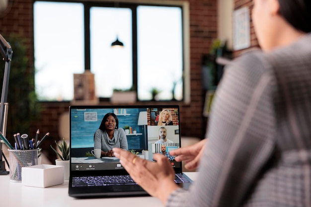 Büroangestellte treffen sich auf einer Remote-Videokonferenz mit Leuten auf einer Laptop-Webcam, die auf einer virtuellen Videoanrufkonferenz chatten. Sprechen im Online-Telefonkonferenz-Chat, Web-Diskussion.