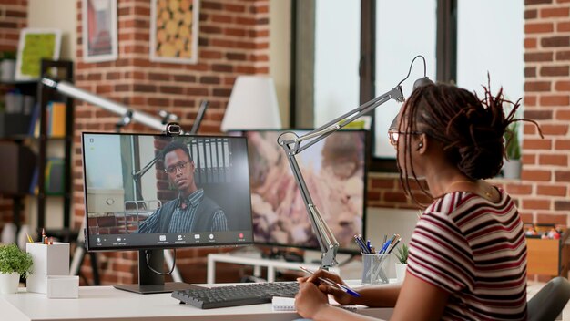 Büroangestellter nimmt an geschäftlichem Videoanruf-Meeting mit Kollegen am Computer mit Webcam teil. Freiberuflerin spricht über Online-Videokonferenz, virtuelle Telefonkonferenz im Internet-Netzwerk.