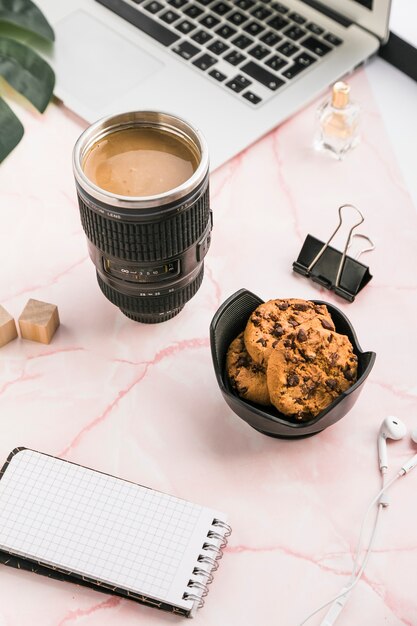 Bürodesktop mit einer Kaffeetasse und Plätzchen