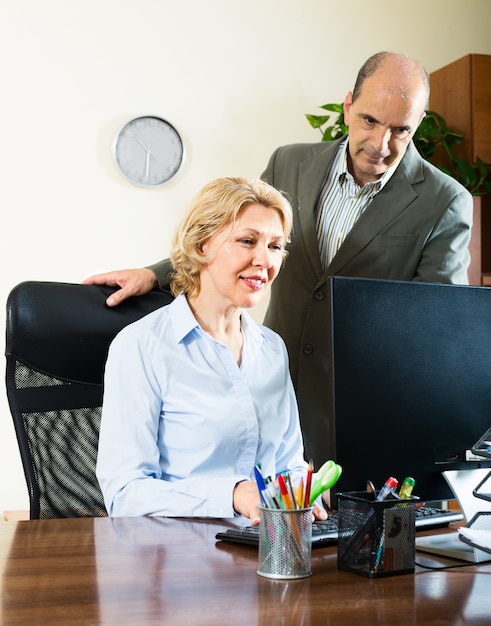 Büroszene mit zwei älteren und positiven Arbeitern