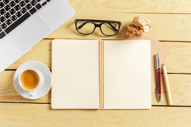 Bürotischhintergrund mit Kaffeetasse, Bleistiften und Computertastatur. Geschäftsarbeitsplatz oder Arbeitsplatzkonzept.