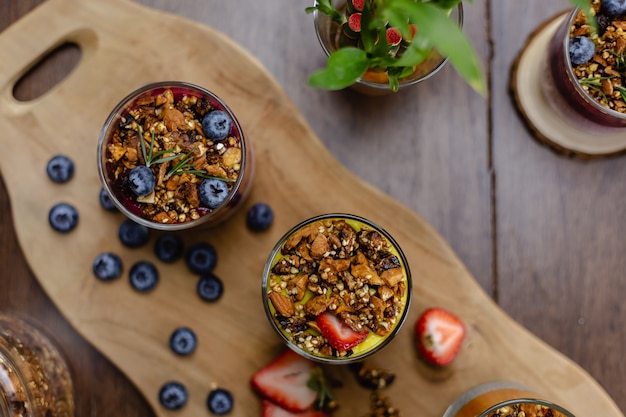 Bunt gesundes Frühstück süße Desserts wenige verschiedene Chia Pudding in Gläsern auf Holztisch in der Küche zu Hause.