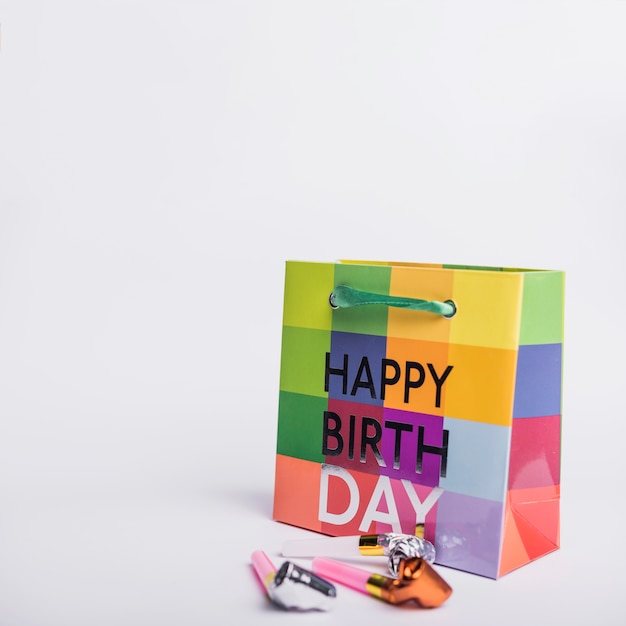 Bunte alles- Gute zum Geburtstageinkaufstasche mit Parteigebläsen auf weißem Hintergrund