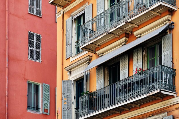 Bunte Architektur der Fenster und Balkone eines roten Gebäudes in Nizza, Frankreich