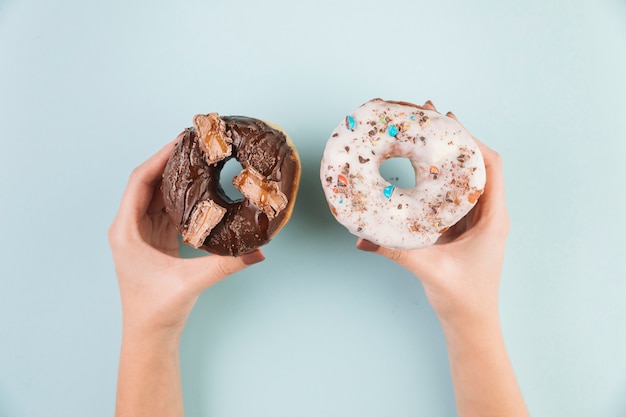 Kostenloses Foto bunte donuts mit den händen