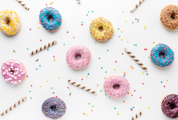 Kostenloses Foto bunte krapfen in der flachen lage