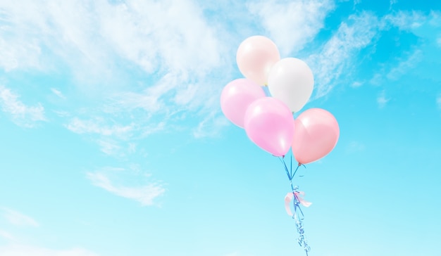 Bunte Luftballons fliegen am Himmel.