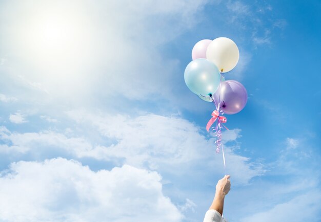 Bunte Luftballons fliegen am Himmel.