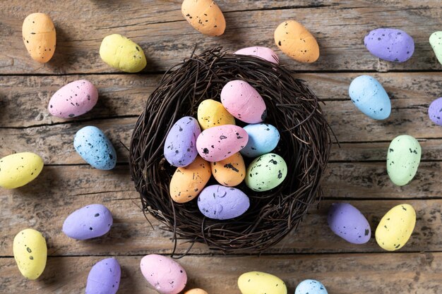 Bunte Ostereier in einem Nest auf Holztisch