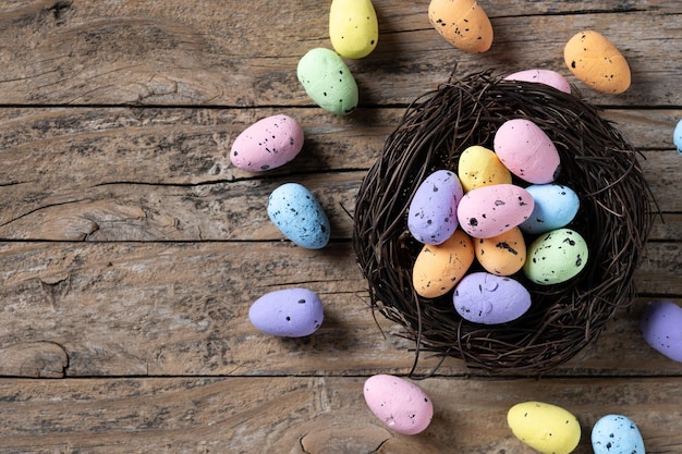 Bunte Ostereier in einem Nest auf Holztisch