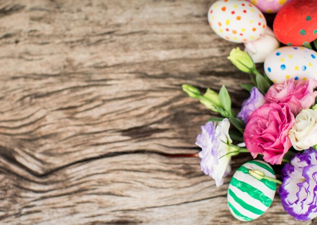 Bunte Ostereier und Lisianthus auf Holztisch