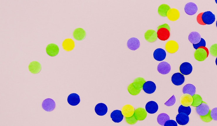 Kostenlose Foto bunte punktkonfettis auf rosa hintergrund