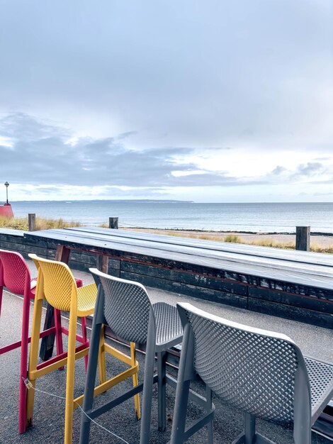 Kostenloses Foto bunte stühle auf der terrasse eines cafés am meer