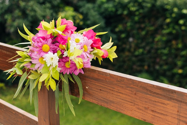Bunter Hochzeitsblumenblumenstrauß gebunden auf hölzernem Geländer