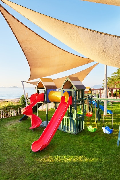 Bunter Spielplatz im Hof im Park bei Sonnenuntergang.