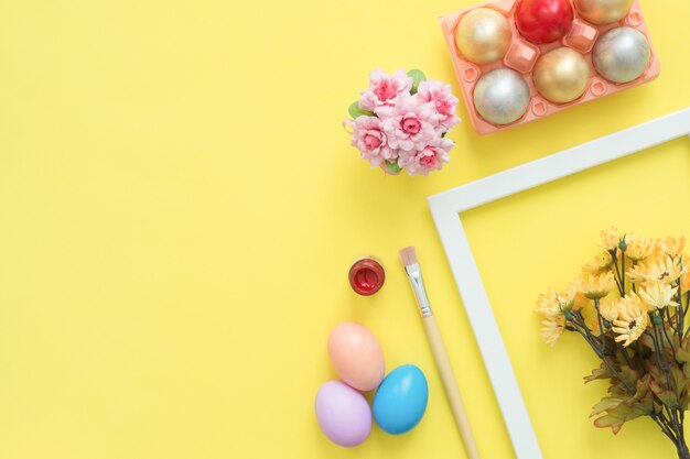 Buntes Osterei der Draufsicht der Draufsicht legen gemalt in der Pastellfarbzusammensetzung und in den Frühlingsblumen