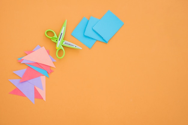 Buntes Papier und Schere auf farbigem Hintergrund