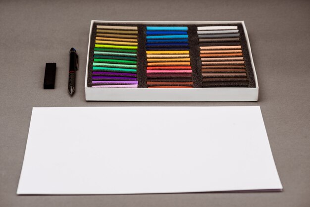 Buntes Pastell, Stift, Papier auf grauem Tisch