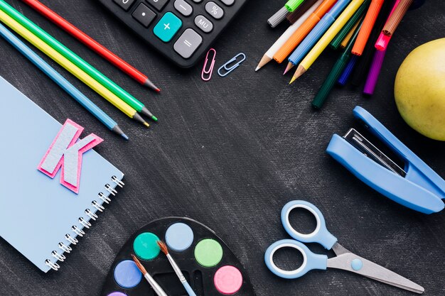 Buntes Schulbriefpapier zerstreut auf Tafel