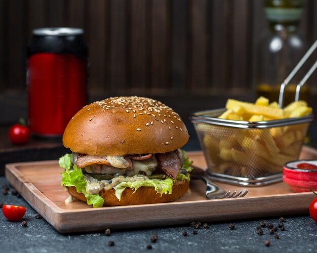 Burger Brötchen gefüllt mit Fleisch und Gemüse und serviert in einem Tablett mit Kartoffeln.