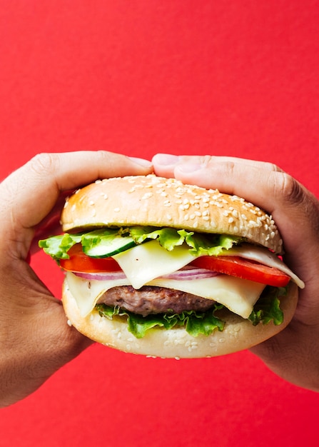 Kostenloses Foto burger mit zwiebel und käse auf rotem hintergrund