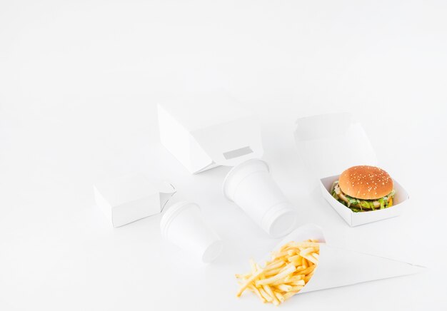 Burger; Pommes frittes; Wegwerfschale und Lebensmittelpaketspott oben auf weißem Hintergrund