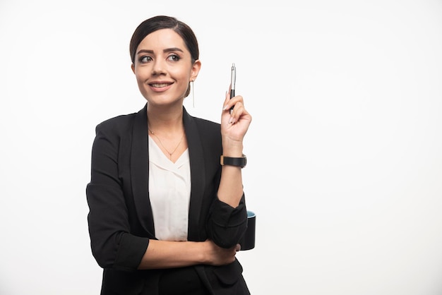 Business-Frau mit Bleistift posiert im Anzug auf weißem Hintergrund. Foto in hoher Qualität