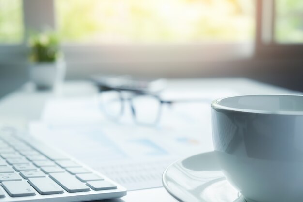 Business-Konzept mit Kopie Raum. Büro Schreibtisch Tisch mit Stift Fokus und Analyse-Diagramm, Computer, Notebook, Tasse Kaffee auf Schreibtisch.Vintage Ton Retro-Filter, selektiven Fokus.