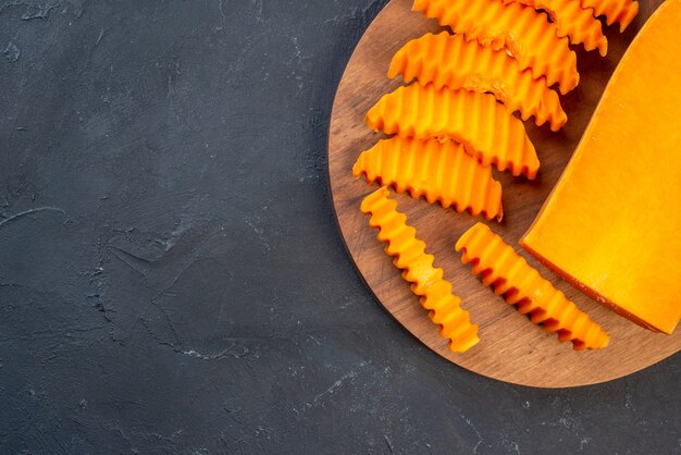 Butternut-Kürbis von oben mit Zick-Zack-Messer auf Holzbrett auf Tischkopierplatz gehackt