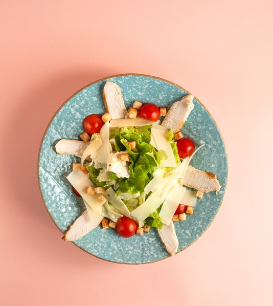 Caesar-Salat mit gegrilltem Hühnchen-Kirsch-Tomaten-Parmezan-Salat und Zwieback auf Teller