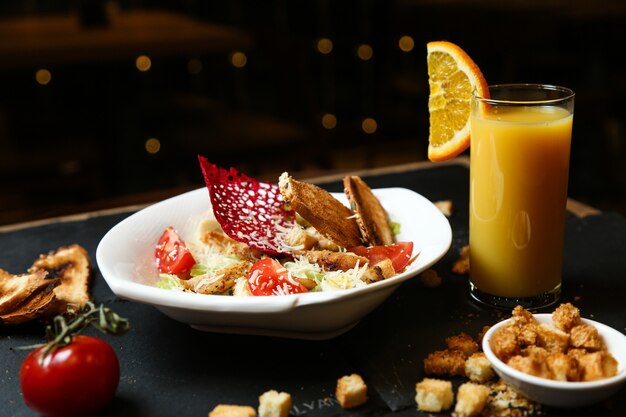 Caesar Salat mit Huhn und Glas Orangensaft