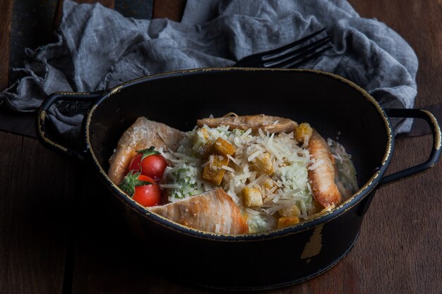 Caesar Salat mit Tomate und Lappen und Gabel in Teller